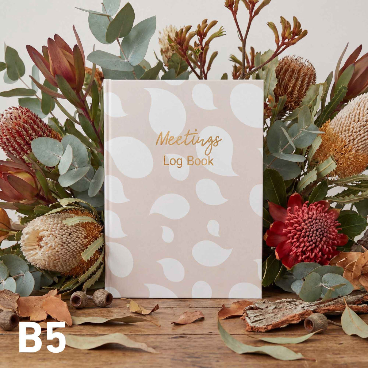 Meetings log book with floral arrangement on a wooden surface
